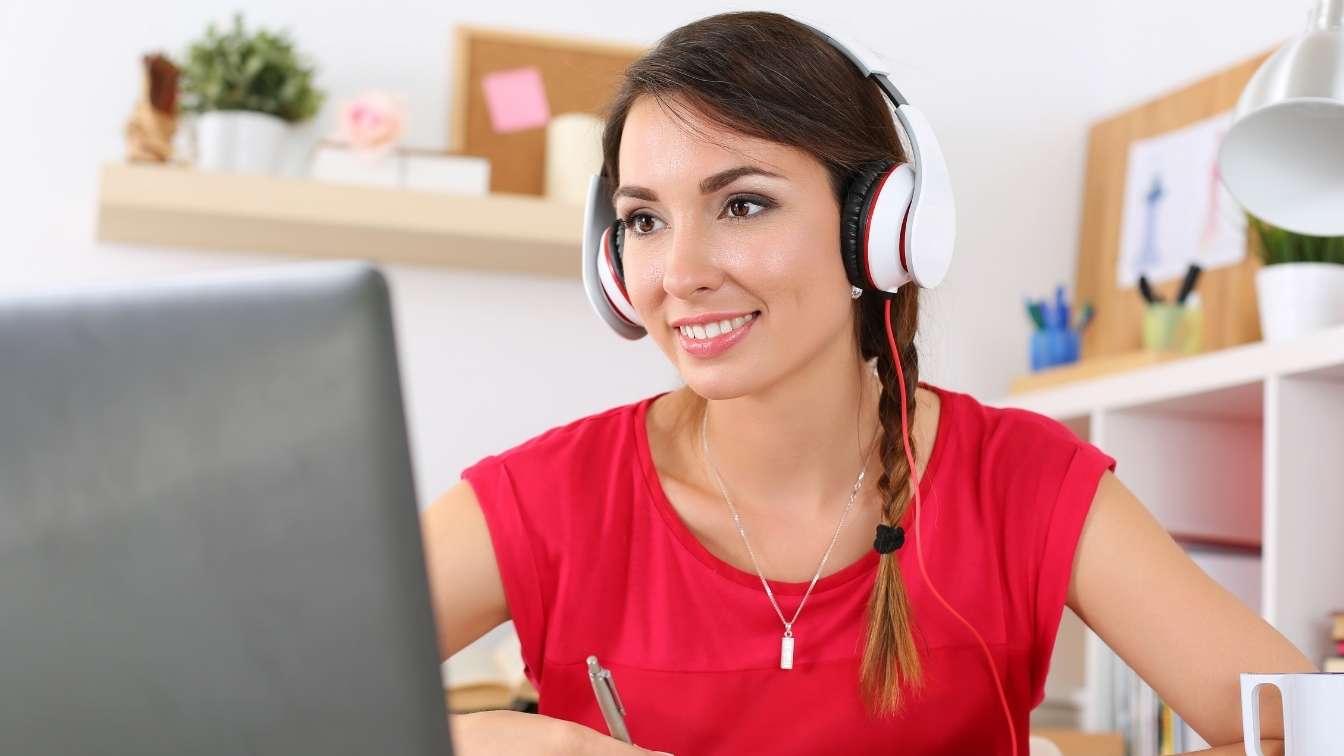 Woman on laptop with headphone taking an online course